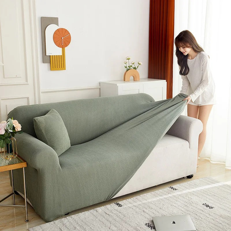 Pose d'une housse de canapé extensible sur un canapé